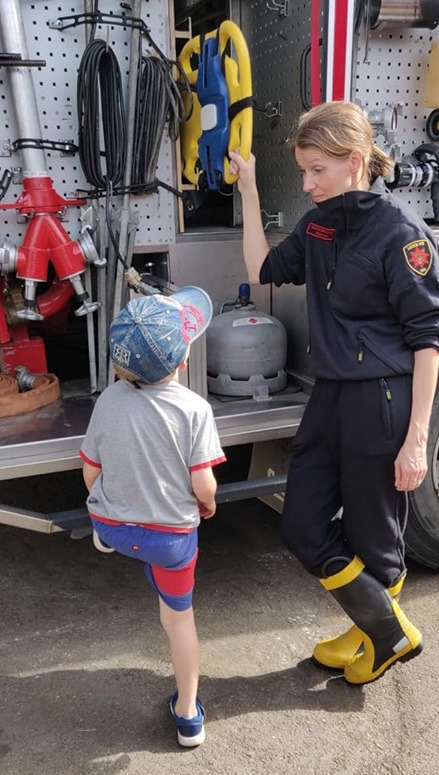 Nainen ja lapsi paloauton kalustoa ihmettelemässä.