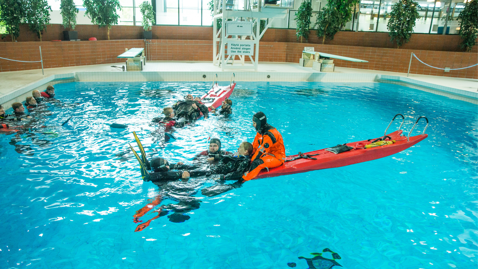 Palokuntalaiset harjoittelevat pintapelastusta uima-altaassa.