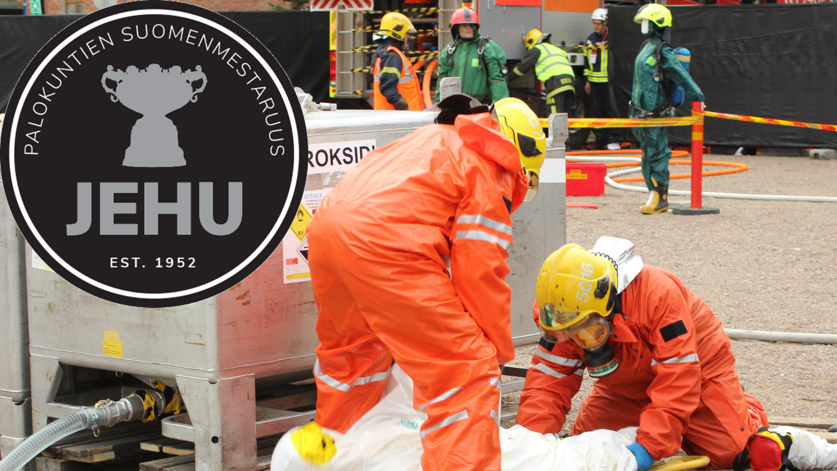 Palokuntalaiset suorittavat kilpailutehtävää oransseissa haalareissa ja kypärät päässä. Yläkulmassa logo JEHU