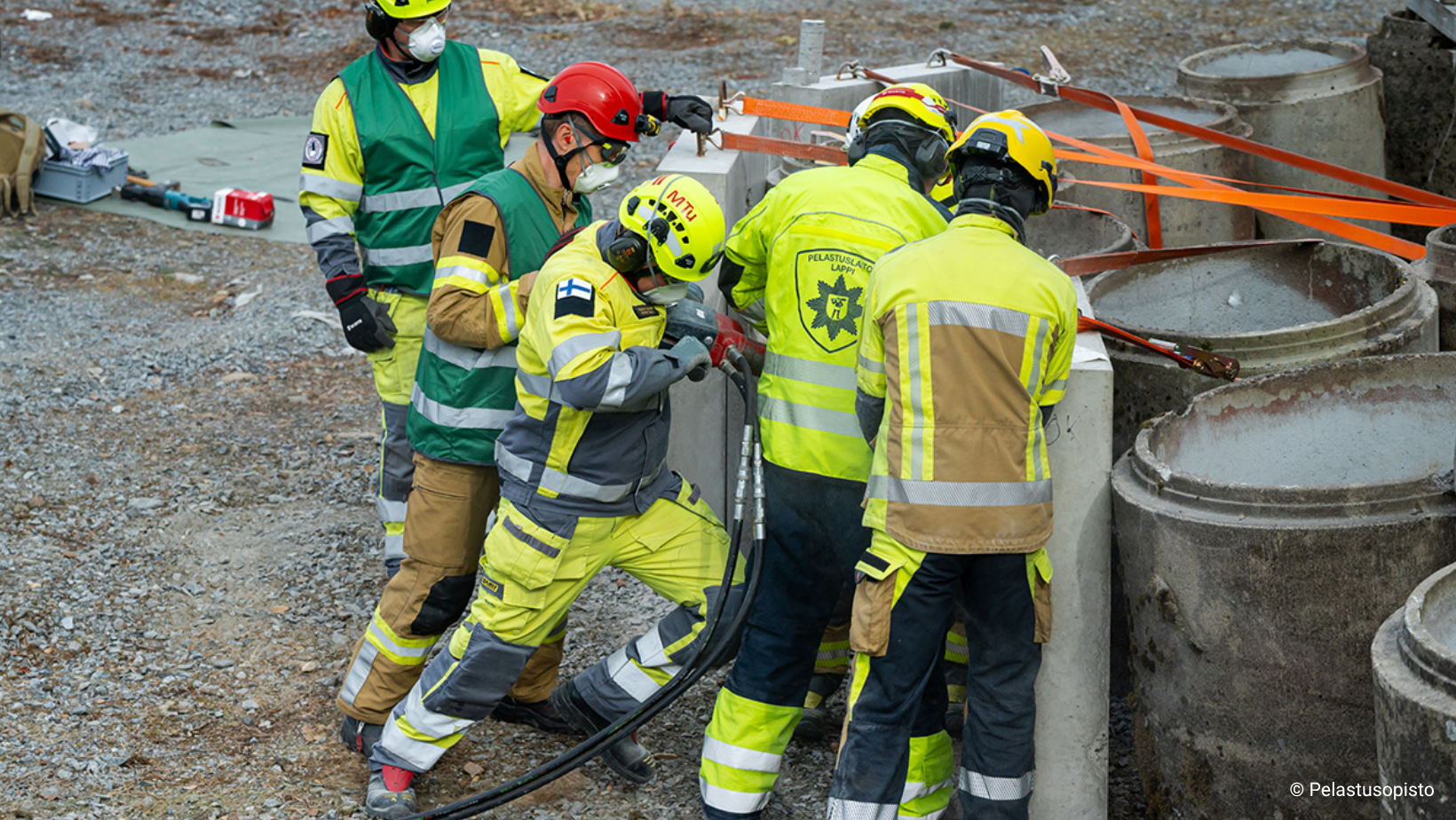 Keltaisissa työvaatteissa olevat pelastajat harjoittelevat betonin läpäisyä.
