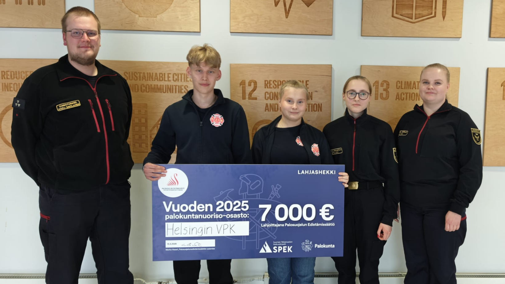 Vuoden palokuntanuoriso-osasto Helsingin VPK poseeraa 7 000 euron lahjashekin kanssa.