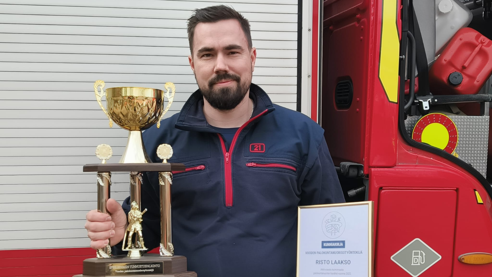 Vuoden palokuntanuorisotyöntekijäksi valittu Risto Laakso poseeraa pokaalin ja diplomin kanssa